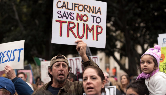 Photo of protestor holding a sign saying 'California says no to Trump'