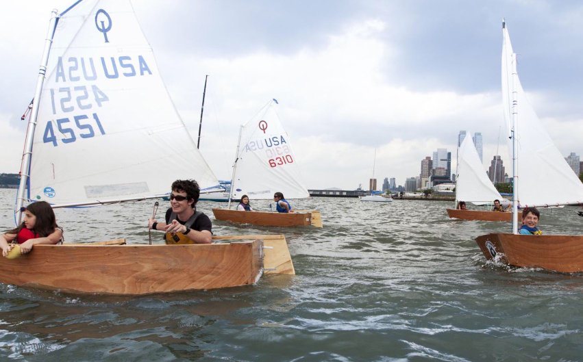 Photograph of young people sailing small boats